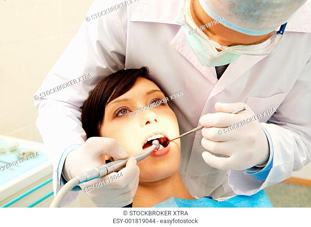 Image of a dentist curing a girlâ€™s teeth