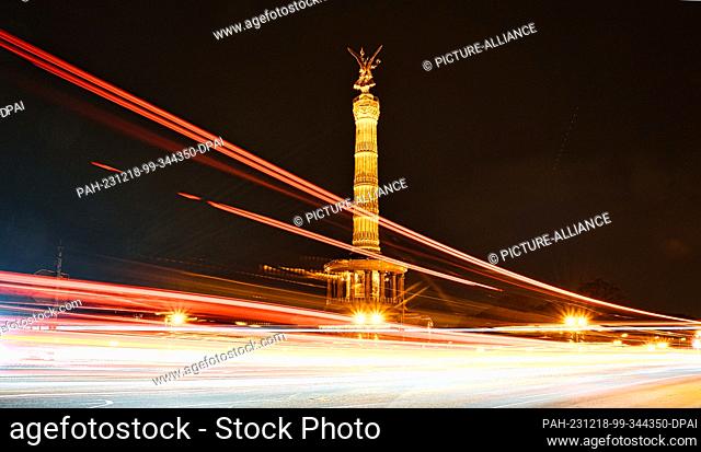 18 December 2023, Berlin: The Victory Column lights up in the evening as vehicles drive past. Since the energy crisis, the building was one of the structures...
