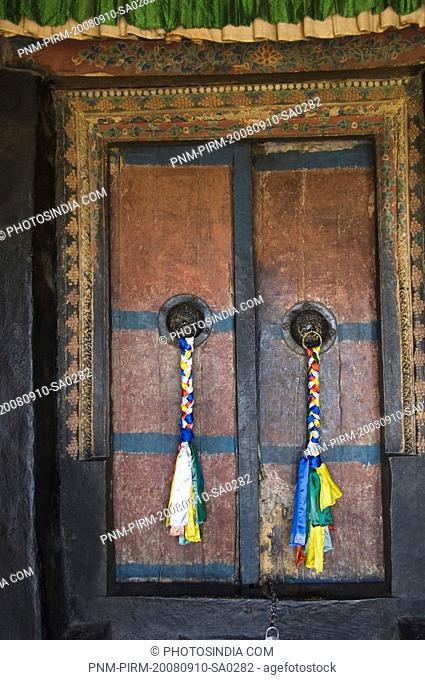 Close-up of prayer flags hanging with door knockers in a monastery, Thiksey Monastery, Ladakh, Jammu and Kashmir, India