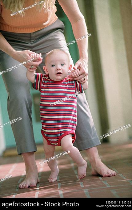 Baby walking with mother's help