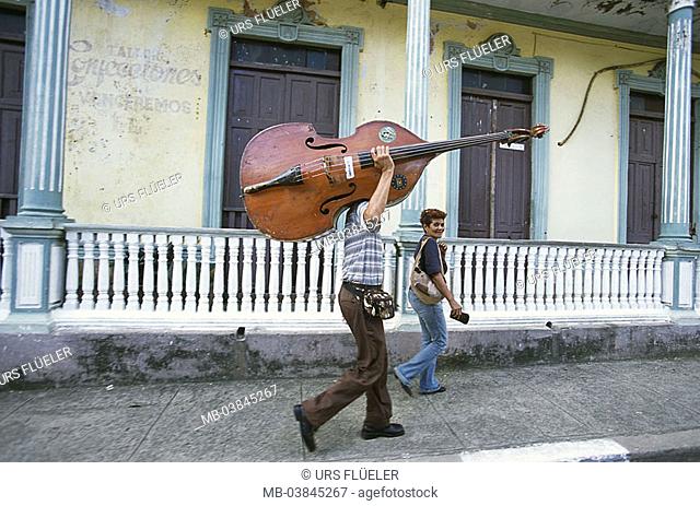 Cuba, Baracoa, alley, woman, man, contrabass, carries, at the side, no models village, buildings, house-facade, balcony, release, Central America, people