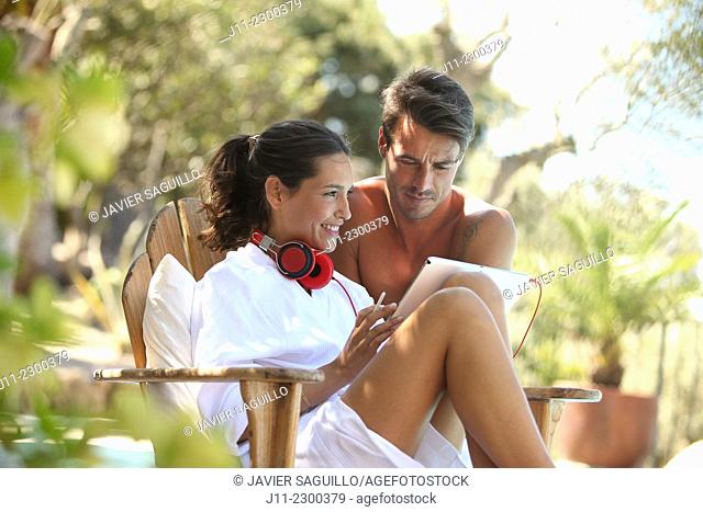 Couple, digital tablet and headphones