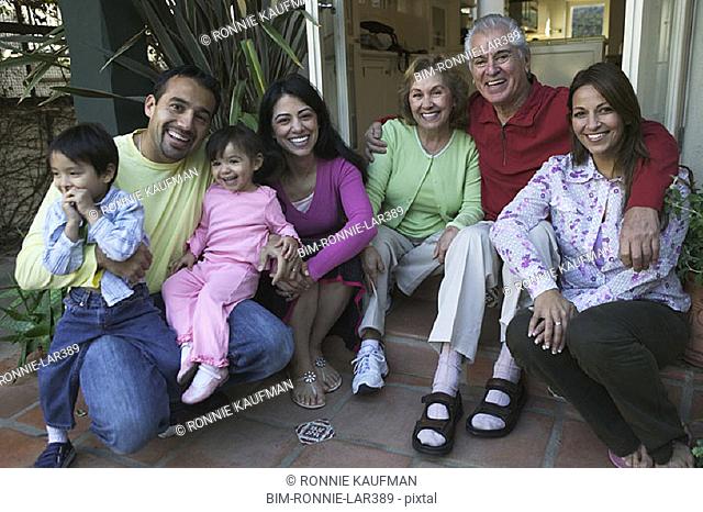 Hispanic family sitting on steps smiling