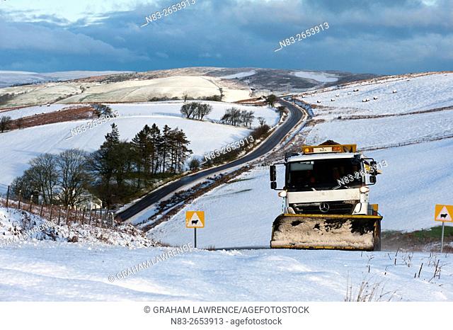 A gritter truck spreads grit on the B4520 road between Brecon and Builth Wells on the Mynydd Epynt moorland, Powys, Wales, UK