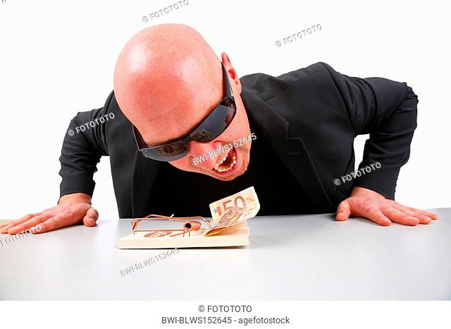 baldheaded man trying to get money out of a trap