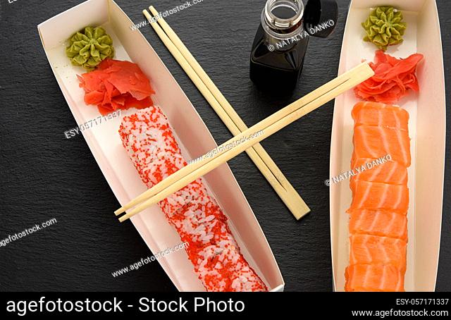 california sushi with red tobiko caviar and slices of philadelphia sushi with eel in a white box, delivery, top view