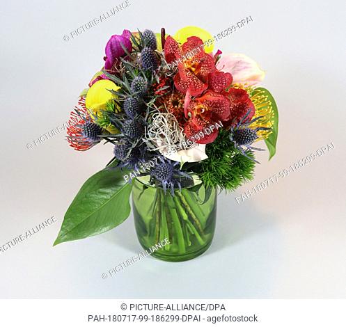 14 March 2018,  Germany, Berlin: A colourful bouquet of flowers consisting of red and yellow pincushion flowers, blue thistle, green anthuriums, pink callas