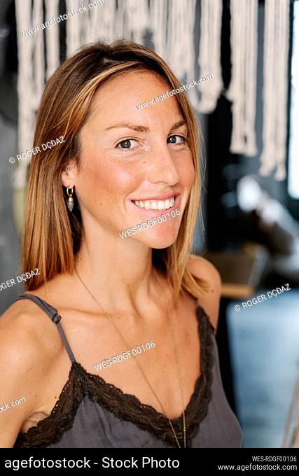 Smiling beautiful woman standing at cafe