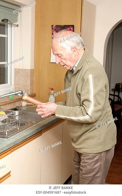 Elderly man working in kitchen
