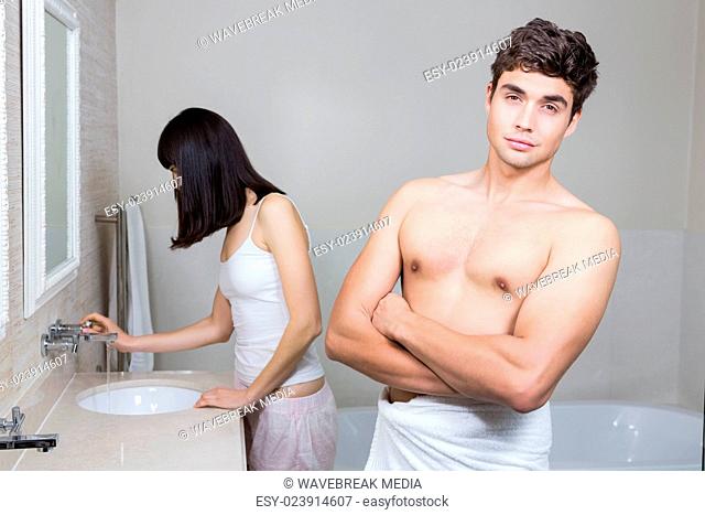 Man looking at camera and woman standing near sink