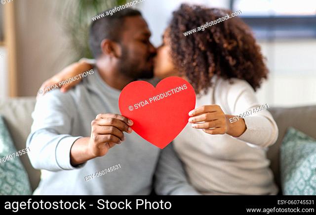 close up of couple with heart kissing at home
