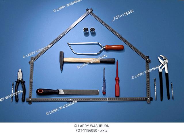 A folding ruler arranged to look like a house with various work tools