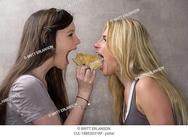 Teen girls share sandwich