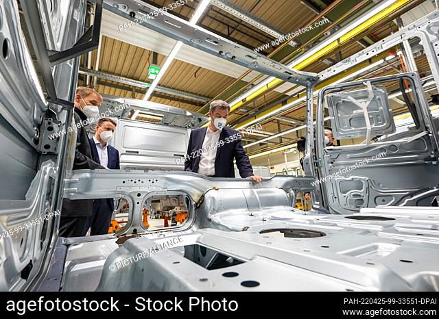 25 April 2022, Bavaria, Munich: Markus Söder, (r, CSU) Minister-President of Bavaria, visits the MAN Truck & Bus plant to find out about truck production