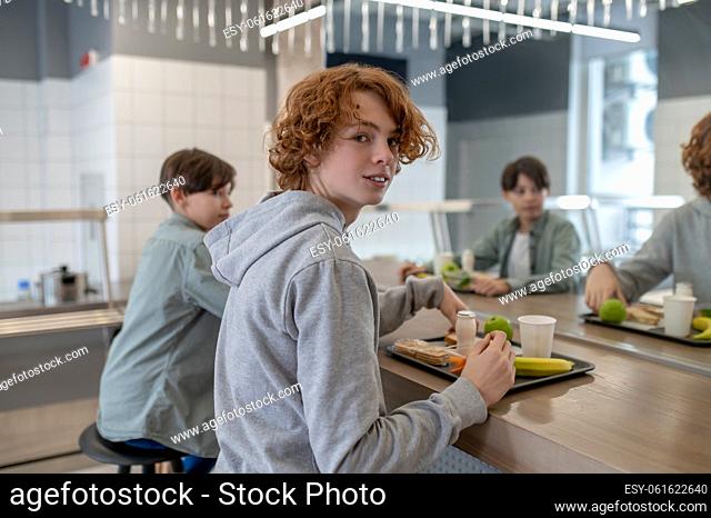 Friends at lunch. Two school boys having lunch in a school canteen