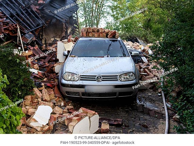 23 May 2019, Schleswig-Holstein, Wohltorf: A car is standing in the ruins of a house that was destroyed in a fire. The fire department was still looking for...