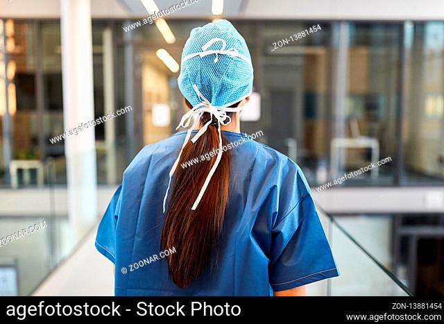 Chirurgin in blauer OP-Kleidung auf dem Weg in die Notaufnahme der Klinik