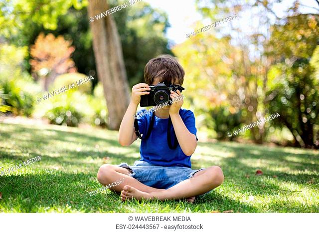 Young boy clicking a photograph from camera