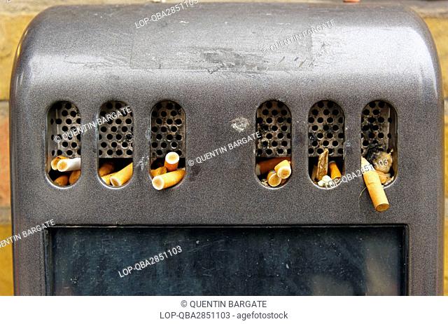 England, London, Shoreditch. Cigarette Butts poking out of a cigarette bin