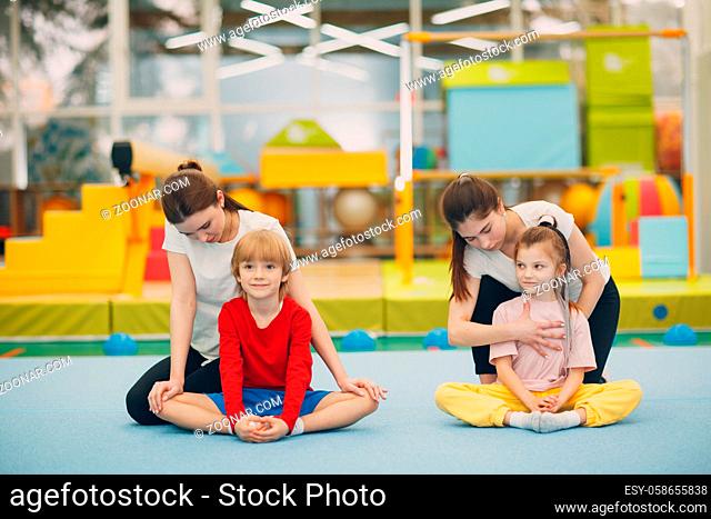 Kids doing stretching exercises in gym at kindergarten or elementary school. Children sport and fitness concept