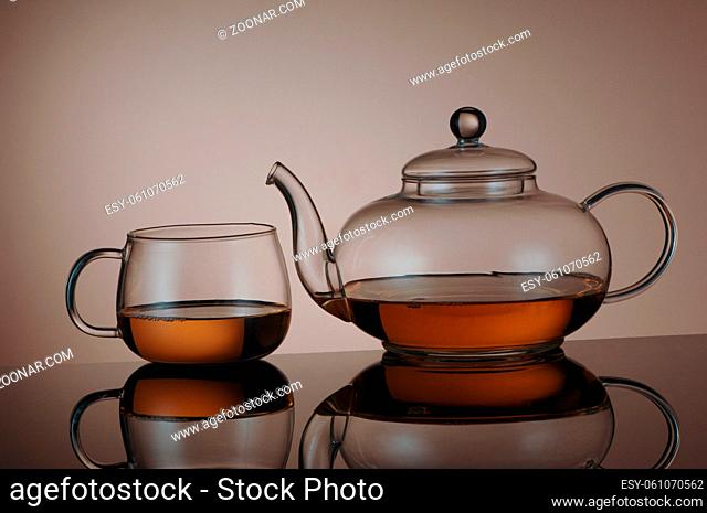 transparent glass teapot and tea cup with reflection