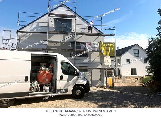 Construction worker on a scaffold. Residential house before completion. Construction industry, newly built apartment, new housing in Grafing Kreis Ebersberg