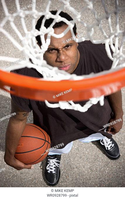 USA, Utah, Salt Lake City, young man looking up at basketball hoop