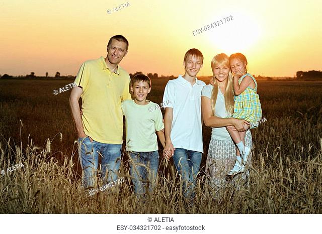 Portrait of happy family running on field road