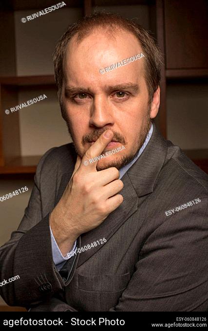 business man in home office with thoughtful look