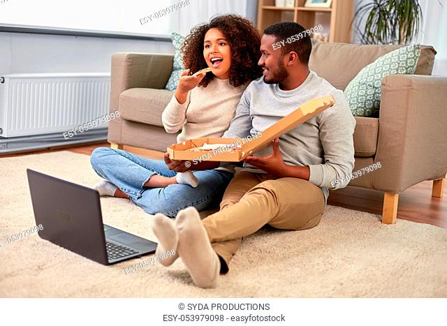 happy african american couple eating pizza at home