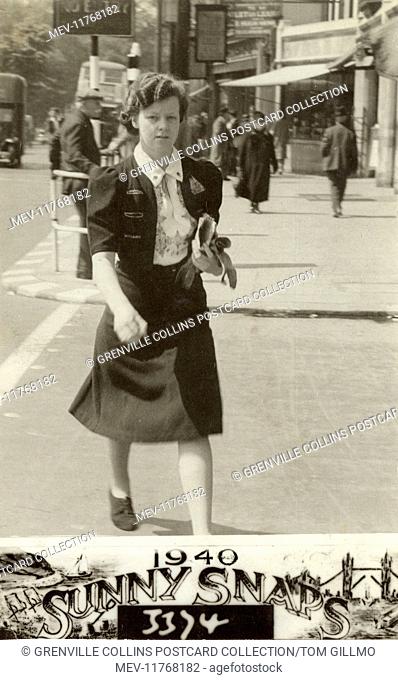 Young lady (Mrs Wiseman) walking purposely down a North London street - she is wearing a very smart and distinctive embroidered blouse and jerkin outfit and has...