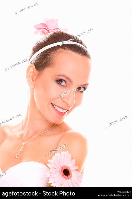 Happy attractive beautiful bride in white wedding dress holding pink gerbera daisy flower. Pretty smiling young woman girl isolated on white background