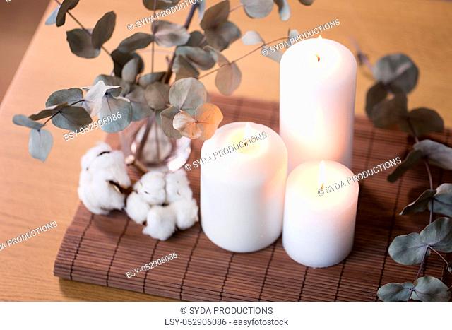 candles and branches of eucalyptus on table