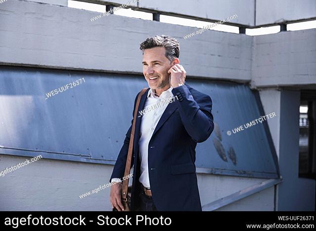 Smiling businessman walking at parking garage