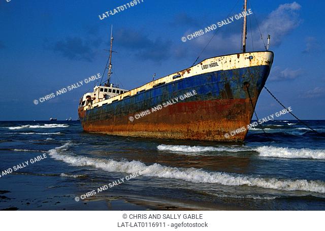 There is a large commercial vessel beached off the shore of Tartus in Syria. It is stranded in shallow water and is rusting
