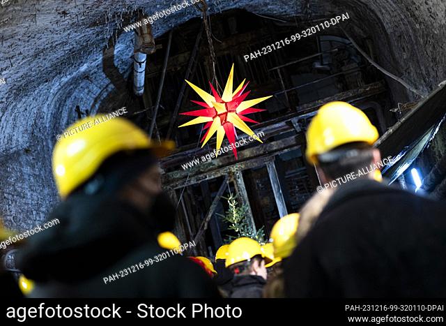 16 December 2023, Lower Saxony, Goslar: Visitors wearing hard hats at a Christmas market in a gallery of the Rammelsberg Mining Museum