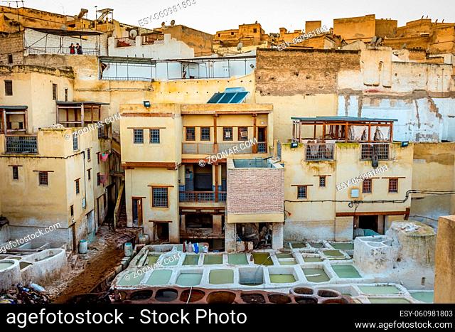 Fes, Morocco on February 22, 2018: A man and woman look over the stone vessels from a building, in tanneries, Fez, Morocco