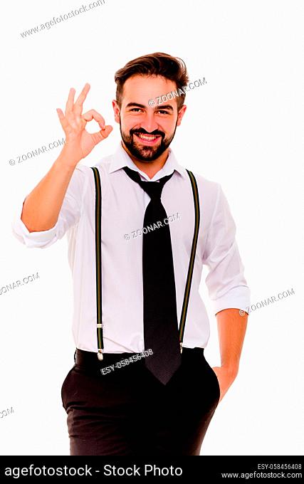 Stylish smiling man In white shirt showing ok. Happy young male standing on white background