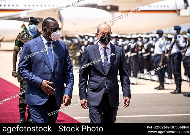 22 May 2022, Senegal, Dakar: German Chancellor Olaf Scholz (SPD), is welcomed with military honors at the airport by Macky Sall (l)