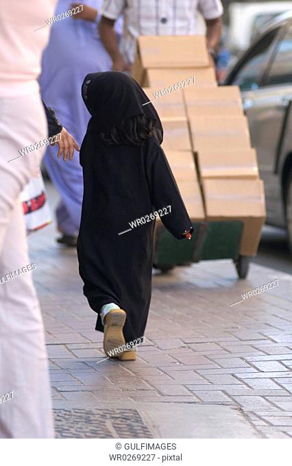 Arab Kid walks on the sidewalk