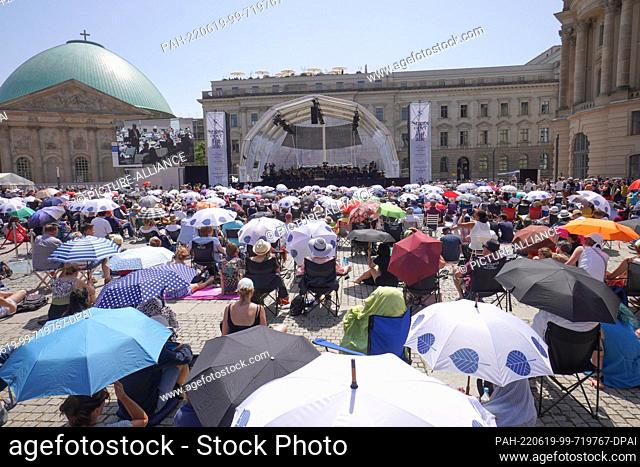 19 June 2022, Berlin: Numerous people who have come to the ""State Opera for All"" on Bebelplatz protect themselves from the heat with umbrellas