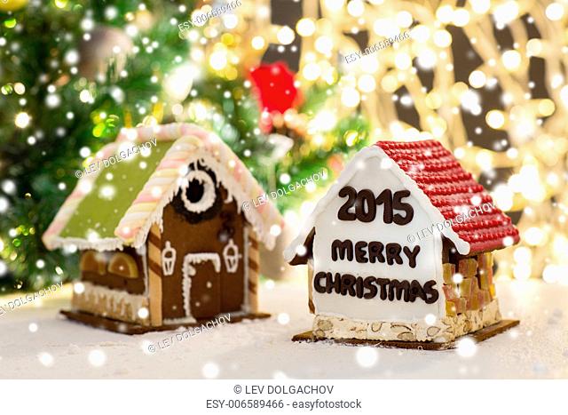 holidays, christmas, baking and sweets concept - closeup of beautiful gingerbread houses on table over lights background