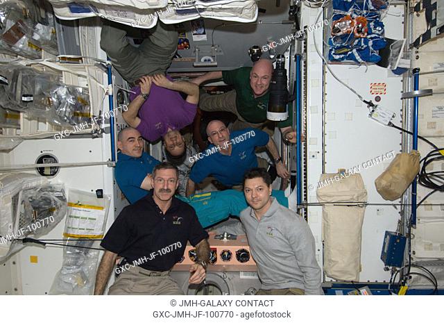 Expedition 30 crew members pose for a photo in the Unity node of the International Space Station. Pictured at bottom are NASA astronaut Dan Burbank (left)