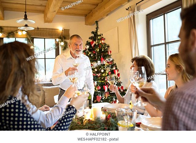 Senior man holding a speech with family at Christmas dinner