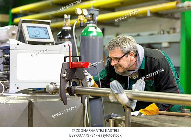 Industrial worker setting orbital welding machine