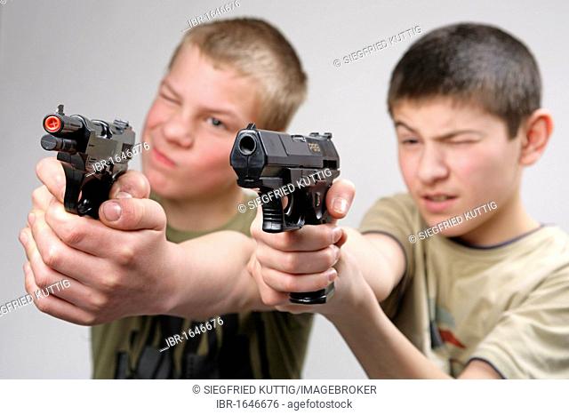 Two boys aiming with toy guns
