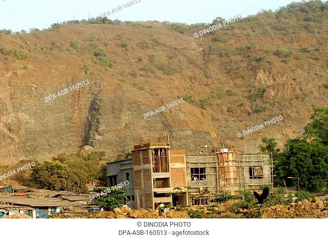 Small hill being destroyed by slowly being destroyed by quarrying and construction to pave way for residential complex in Bombay Mumbai ; Maharashtra ; India