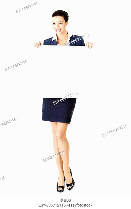 Smiling young business woman showing blank signboard, over white background isolated