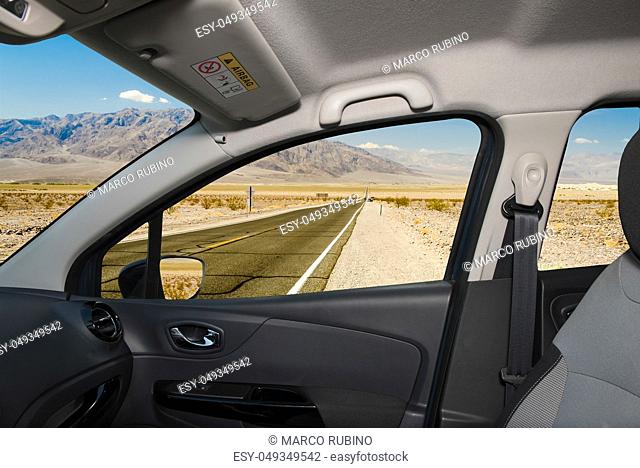 Looking through a car window with view of a hot desert road in Death Valley National Park, California, USA