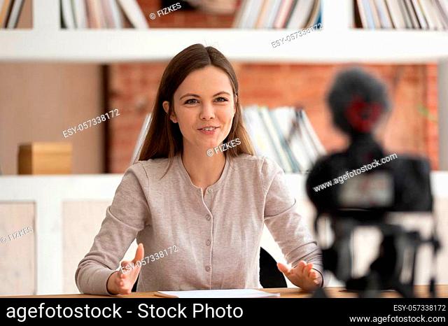 Smiling young female tutor or coach talk at professional camera shooting online training study course, positive motivated girl vlogger speak with viewers making...